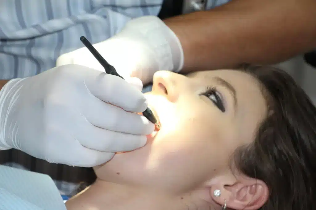 A woman undergoes dental scaling and polishing.