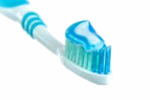 A blue and white toothbrush with toothpaste.