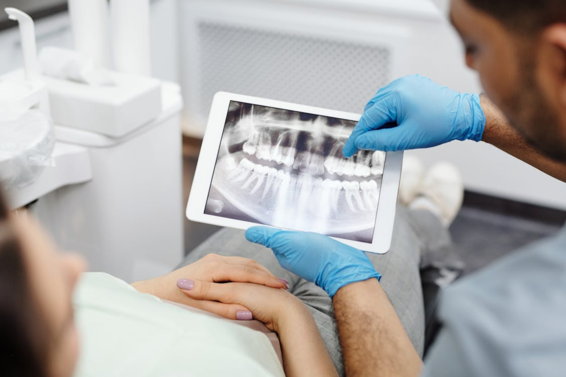 a dentist showing an X-ray of the teeth to his patient
